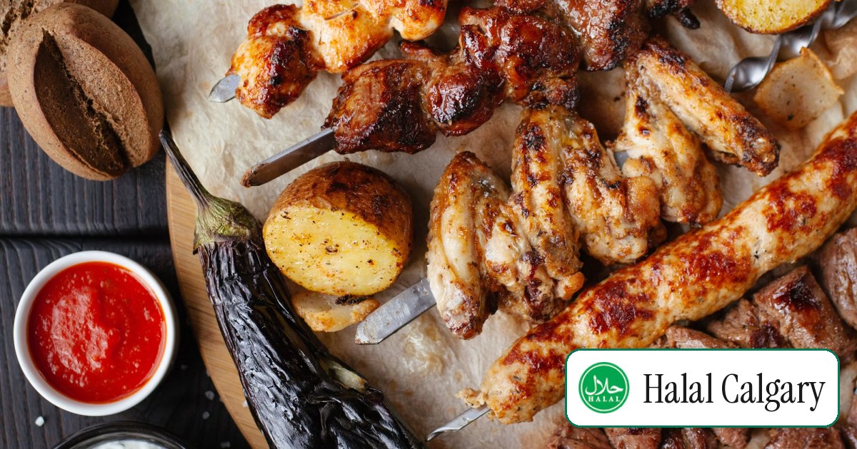 A spread of grilled kebab skewers, wings and vegetables laid out on flatbread