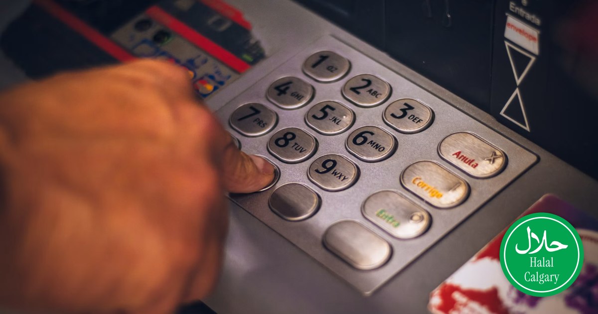 A hand entering a PIN on a bank machine keypad