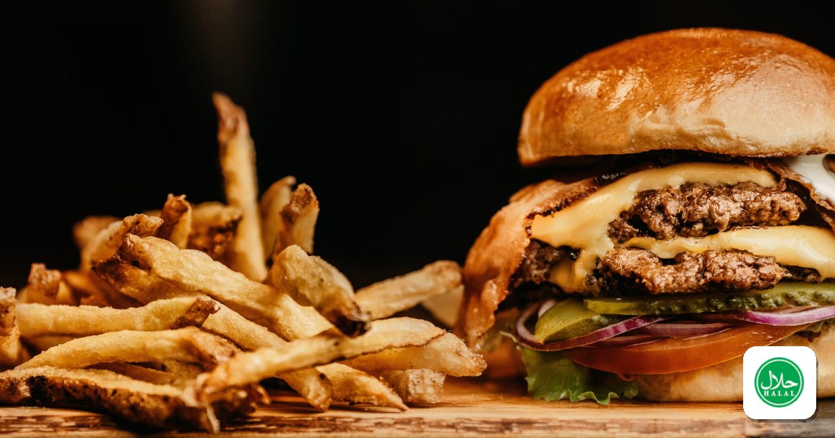 A halal beef burger with crispy fries on a wooden board