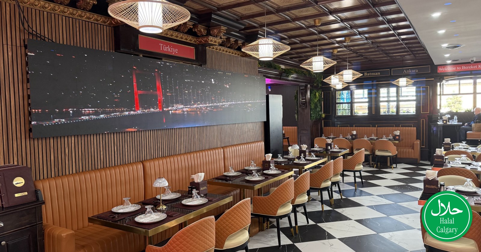 The warmly lit dining room at Bereket Kebab House, booths along the wall