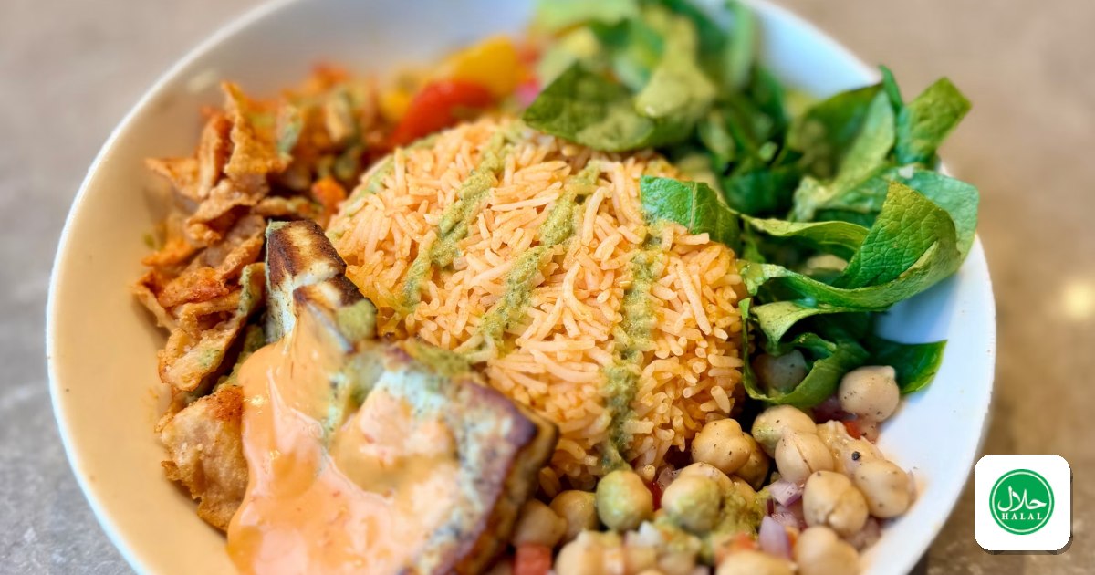 A halal lunch bowl with rice, grilled chicken, chickpeas, and greens