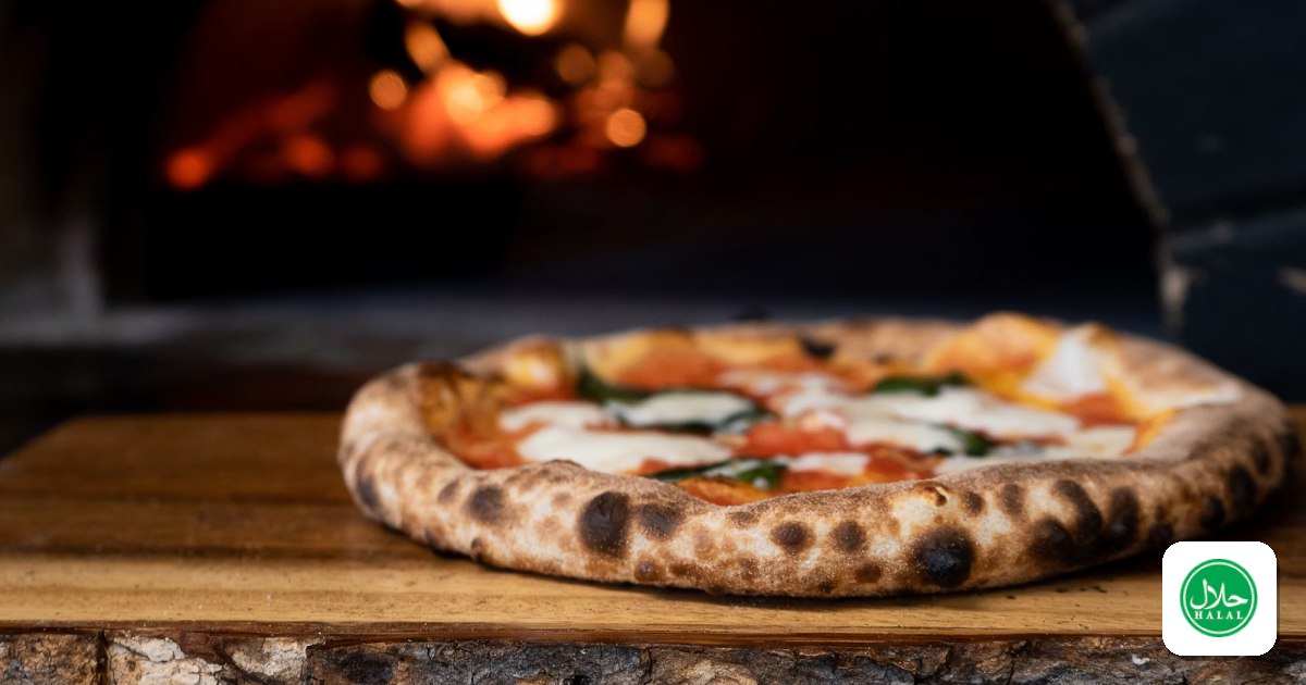 A margherita pizza on a wooden board in front of a wood-fired oven