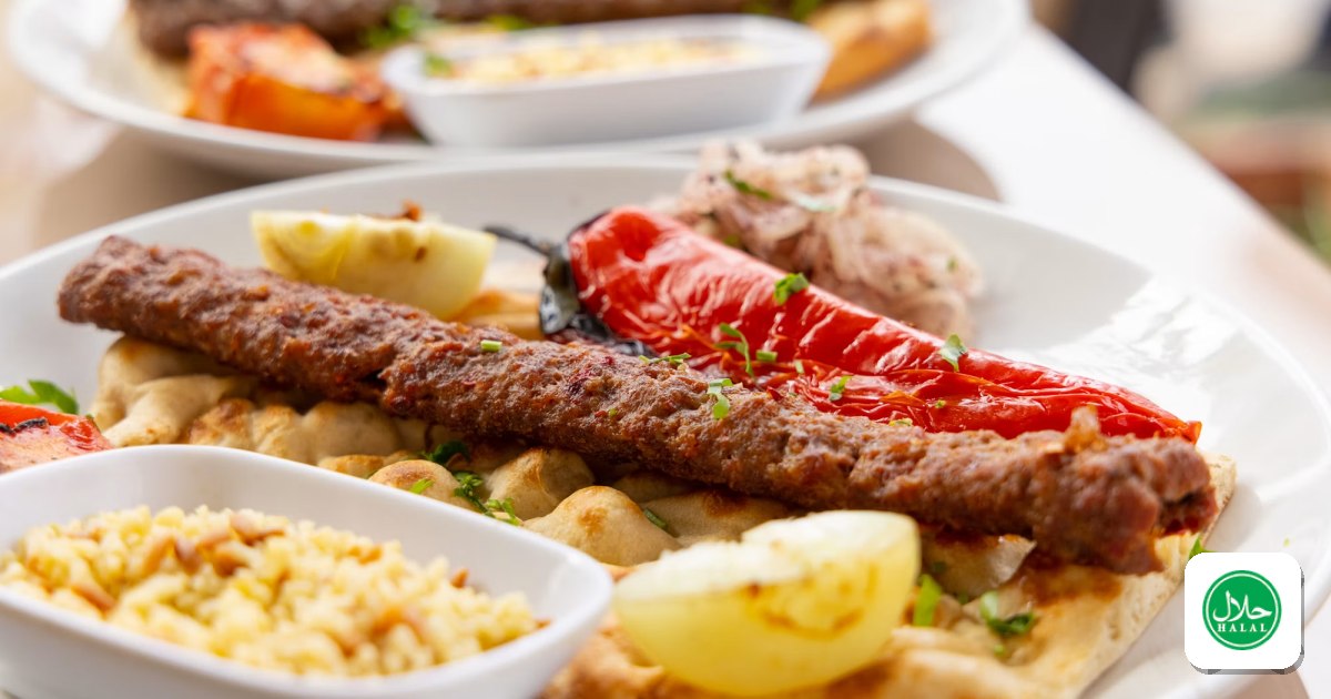 Adana kebab served on flatbread with grilled pepper, bulgur and lemon