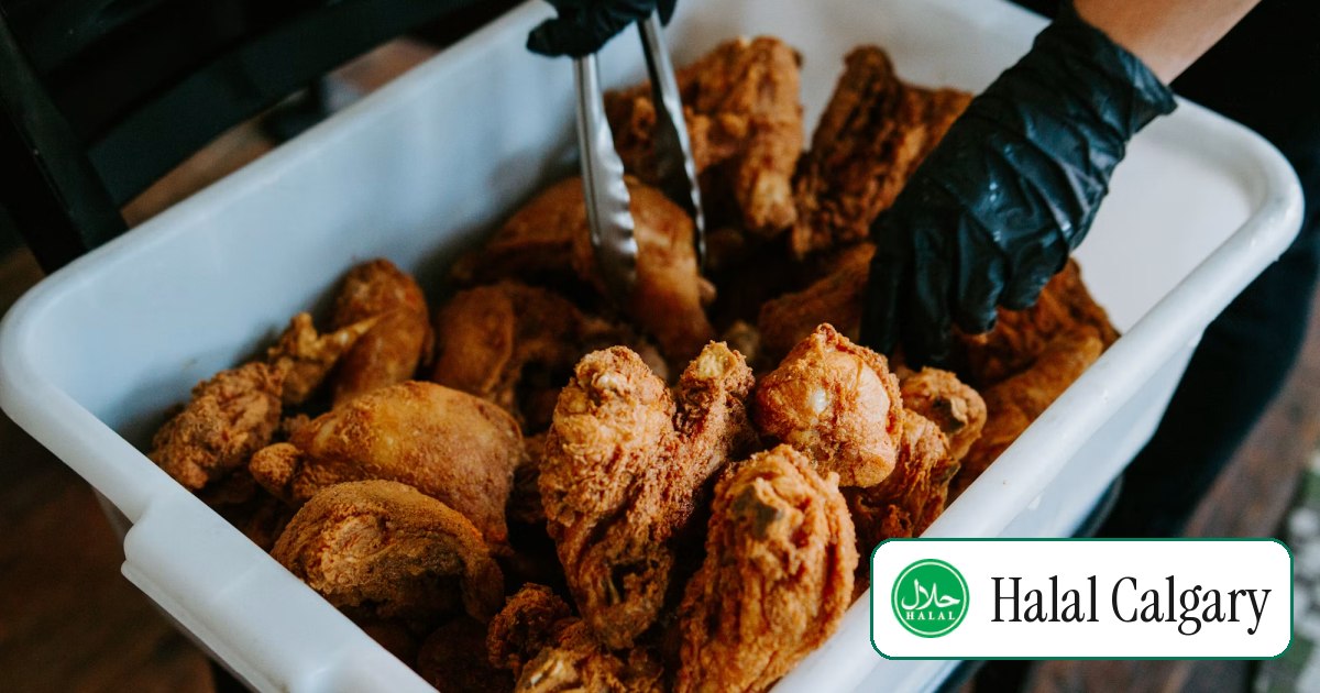A tray of fried chicken being served with tongs
